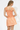 Woman wearing an orange and white checkered dress on a white background