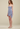 Woman wearing a light blue dress against a beige background