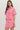 Woman wearing a pink outfit with red floral patterns on a white background