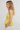 Woman wearing a yellow checkered top against a plain background