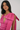 Woman wearing a pink dress with a bow detail on a white background