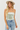 Woman wearing a strapless sequin top and jeans with a white background