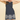 Woman wearing a navy dress with white lace details on a beige background