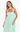 Woman wearing a light green dress with ruffled layers on a white background
