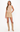 A woman modeling a beige sleeveless ribbed knit top and matching beige mini skirt set, paired with beige knee-high boots, against a plain white studio background.