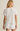 Woman wearing a white ribbed t-shirt and shorts set on a beige background
