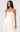 Woman wearing a white strapless dress against a plain background