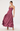 A woman modeling a floor-length satin maxi dress in a dusty rose or mauve shade. The dress features a structured, embellished lace-like bodice with thin spaghetti straps and a voluminous, flowing skirt.