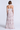 Woman wearing a strapless, tiered dress with a floral pattern on a white background