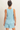 Woman wearing a light blue sleeveless top and shorts set on a beige background