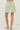 Green and white striped skirt worn by a person on a white background