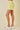 Yellow lace shorts worn by a person on a beige background