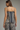 A woman shown from the back wearing a matching sleeveless camisole and shorts set with a navy blue and beige zebra print pattern.