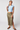 Woman wearing a light blue crop top and beige skirt on a white background