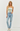 Woman wearing a strapless top and light blue jeans against a white background