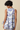 Woman wearing a sleeveless floral dress against a beige background