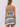 A woman shown from the back wearing a fitted mini dress with thin straps and a flared skirt, featuring horizontal stripes in brown, light blue, cream, and white.