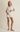 Woman wearing a white ribbed outfit on a beige background