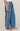 Blue denim pants with a white stripe on a neutral background