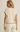 Woman wearing a cream sweater with red trim on a plain background