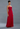 Woman wearing a strapless red evening gown against a gray background