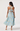 Woman wearing a light blue floral dress with cut-out back on a white background