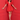Woman in a red dress standing against a red wall