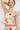 Woman wearing a floral two-piece set against a plain background