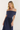 Woman wearing a navy off-shoulder dress on a white background