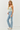 Woman wearing a strapless top and light blue jeans on a white background