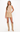 A woman modeling a beige sleeveless mock-neck top and matching beige mini skirt, paired with beige knee-high boots, against a plain white studio background.