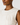 Close-up of a person wearing a beige sleeveless top against a light background