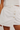 White denim skirt with button details on a plain background