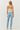 Woman wearing a strapless top and light blue jeans on a white background