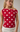 Woman wearing a red polka dot top against a neutral background