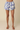 Floral shorts worn by a person on a beige background