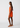 Woman wearing an orange dress with a white pattern on a white background