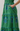 Green dress with blue floral embroidery on a plain background
