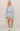 Woman wearing a light blue outfit with shorts and a top on a plain background