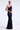 Woman wearing a one-shoulder purple sequin gown on a white background