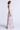 Woman wearing a long, floral tiered dress on a white background