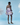 Model wearing a purple ruffled dress against a light blue background with floral elements.