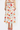 Woman wearing a floral dress with red shoes on a white background