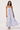 Woman wearing a strapless dress with blue and white pattern on a white background