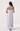 Woman wearing a strapless dress with blue and white pattern on a white background