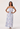 Woman wearing a strapless dress with blue and white pattern on a white background