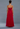 Woman wearing a strapless red gown against a gray background