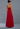 Woman wearing a red strapless gown against a gray background