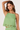 Woman wearing a green top with lace details on a white background