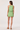 Woman wearing a green dress with floral embroidery on a white background